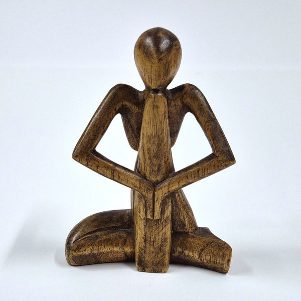 Vintage handgesneden houten beeldje van een gezeten figuur, volkskunst