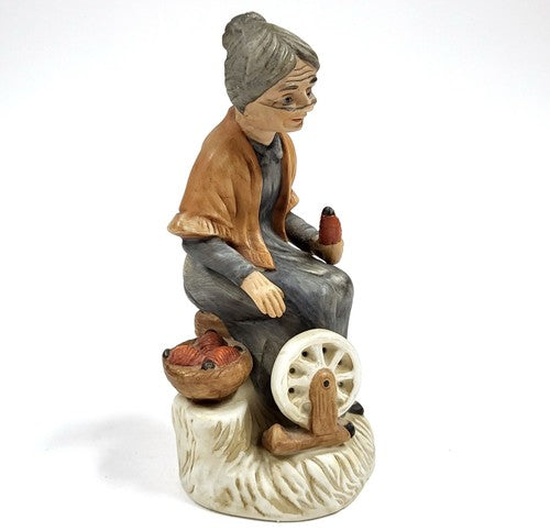 Vintage keramisch beeldje van een oude vrouw bij het spinnewiel